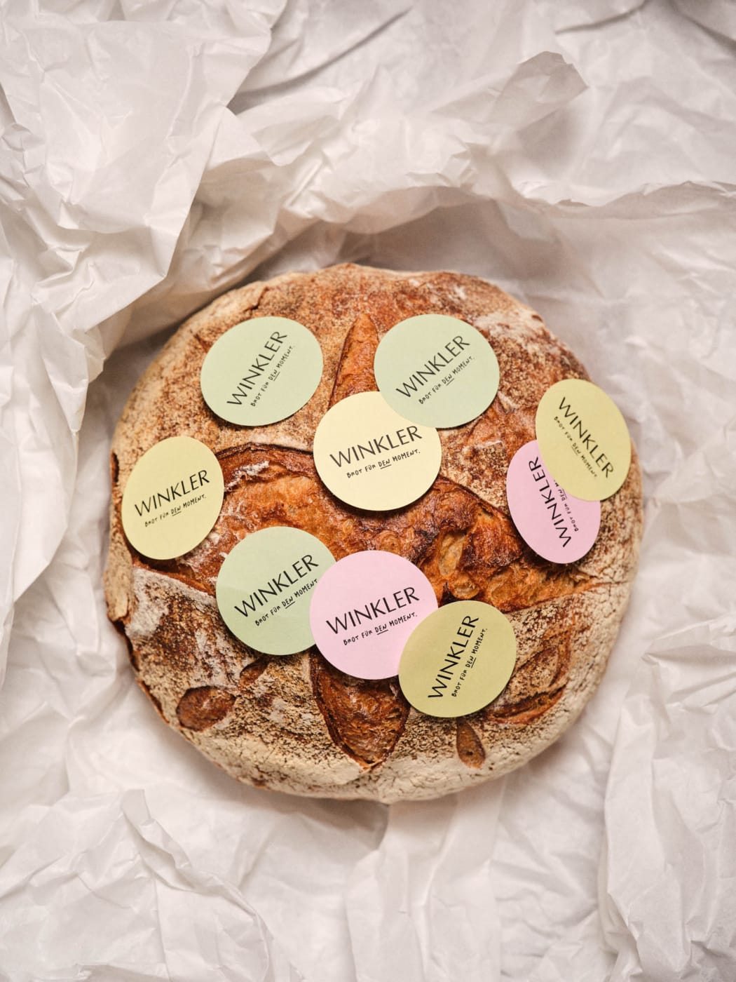 Bäckerei Branding für die Bäckerei Winkler mit gebrandeten Etiketten auf einem handwerklich gebackenen Brot und einer natürlichen, modernen Markenwelt