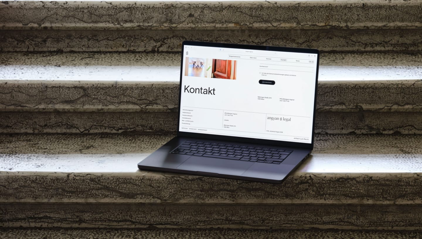 Geöffneter Laptop steht auf Stufen und zeigt gestaltete Webstite von Angyan Legal, Rechtsanwalt in Wien