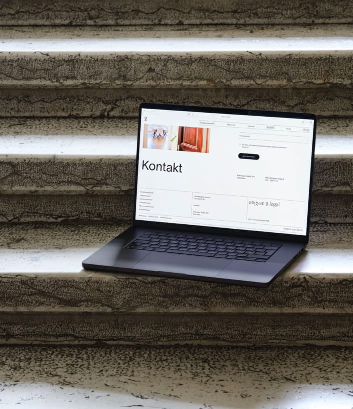 Geöffneter Laptop steht auf Stufen und zeigt gestaltete Webstite von Angyan Legal, Rechtsanwalt in Wien